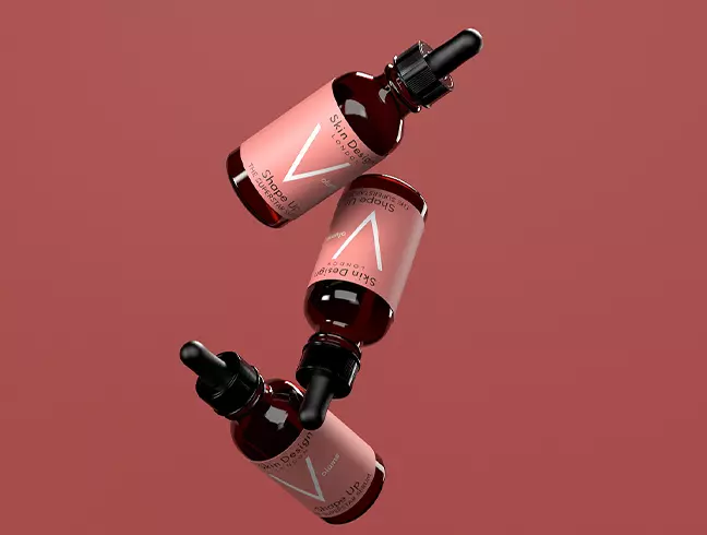 Amber dropper bottles with pink labels and a V monogram on a deep red backdrop
